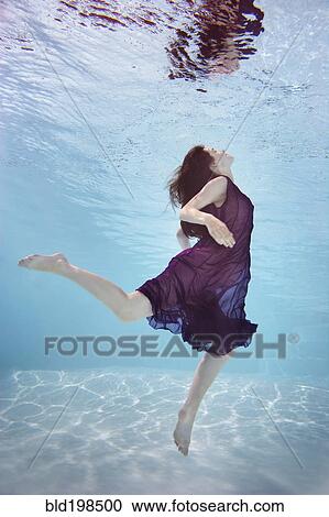 Caucasian woman in dress swimming underwater View Large Photo Image Stock Image - Caucasian woman in dress swimming underwater. Fotosearch