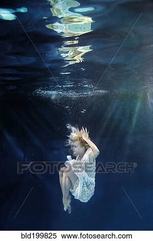 Caucasian woman in dress swimming under water View Large Photo Image Stock Photography - Caucasian woman in dress swimming under water. Fotosearch