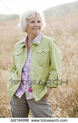 Caucasian woman in field with hands in pockets View Large Photo Image Stock Photograph - Caucasian woman in field with hands in pockets. Fotosearch