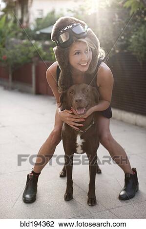 Stock Image - Caucasian woman in fur hat riding dog. Fotosearch