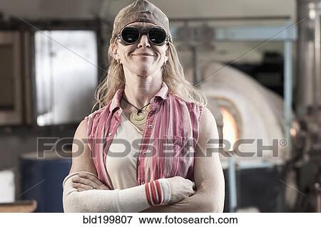 Stock Photo - Caucasian woman in glass blowing studio. Fotosearch