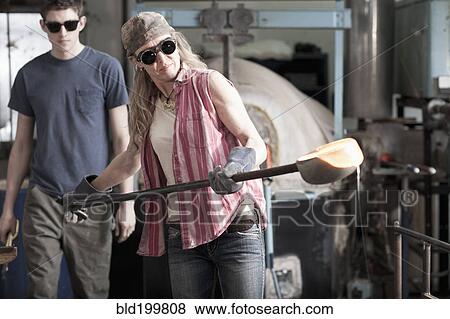 Stock Photo - Caucasian woman in glass blowing studio. Fotosearch
