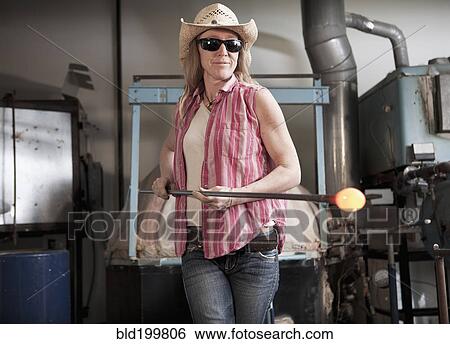 Stock Photograph - Caucasian woman in glass blowing studio. Fotosearch