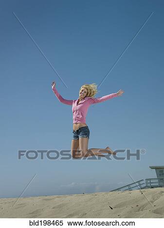 Caucasian woman jumping on beach View Large Photo Image Stock Photography - Caucasian woman jumping on beach. Fotosearch