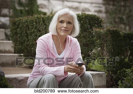 Caucasian woman listening to mp3 player View Large Photo Image Stock Photo - Caucasian woman listening to mp3 player. Fotosearch
