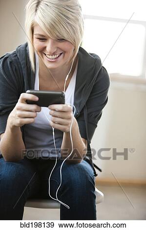 Caucasian woman listening to music on mp3 player View Large Photo Image Stock Photo - Caucasian woman listening to music on mp3 player. Fotosearch