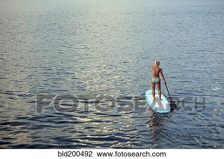 Caucasian woman on paddleboard on lake View Large Photo Image Stock Image - Caucasian woman on paddleboard on lake. Fotosearch