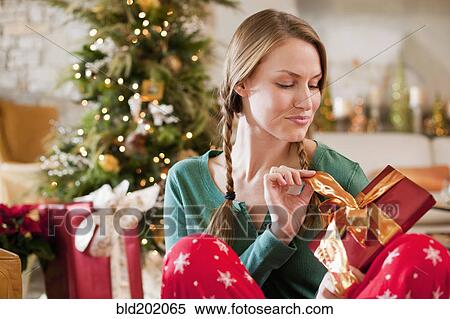 Caucasian woman opening Christmas gift View Large Photo Image Stock Photography - Caucasian woman opening Christmas gift. Fotosearch