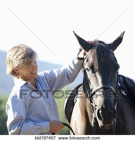 Caucasian woman petting horse View Large Photo Image Stock Photo - Caucasian woman petting horse. Fotosearch