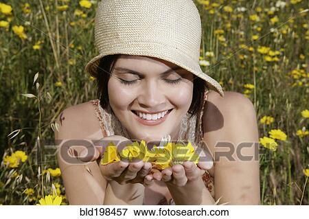 Stock Photo - Caucasian woman picking wildflowers in field. Fotosearch