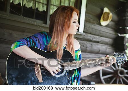 Stock Photo - Caucasian woman playing guitar. Fotosearch