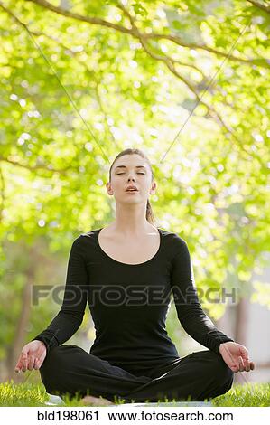 Caucasian woman practicing yoga in park View Large Photo Image Stock Image - Caucasian woman practicing yoga in park. Fotosearch