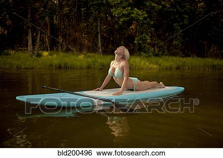 Caucasian woman practicing yoga on paddleboard View Large Photo Image Stock Photograph - Caucasian woman practicing yoga on paddleboard. Fotosearch