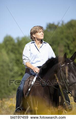 Stock Photo - Caucasian woman riding horse. Fotosearch