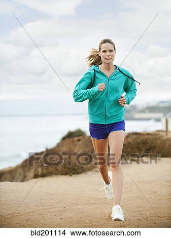 Picture - Caucasian woman running on beach. Fotosearch
