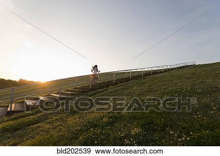 Stock Photo - Caucasian woman running up steps. Fotosearch