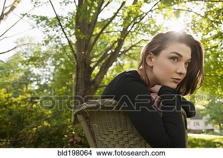 Picture - Caucasian woman sitting in chair outdoors. Fotosearch