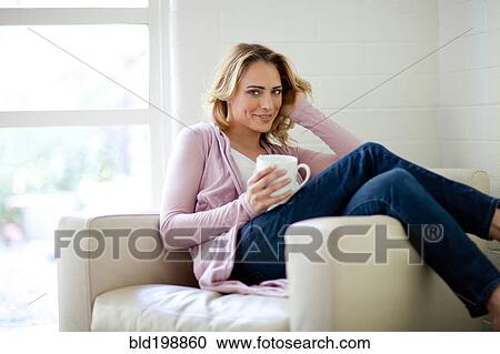 Caucasian woman sitting in chair drinking coffee View Large Photo Image Stock Image - Caucasian woman sitting in chair drinking coffee. Fotosearch