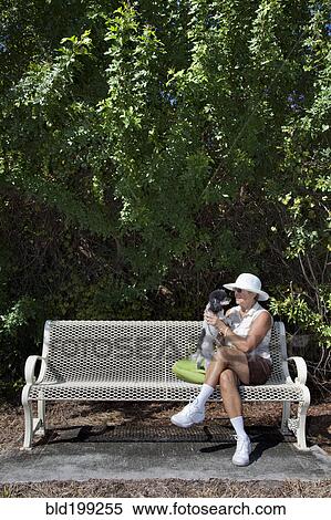 Caucasian woman sitting on park bench with dog View Large Photo Image Stock Photography - Caucasian woman sitting on park bench with dog. Fotosearch