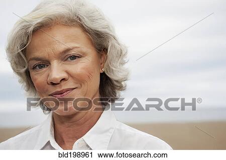 Stock Image - Caucasian woman standing on beach. Fotosearch