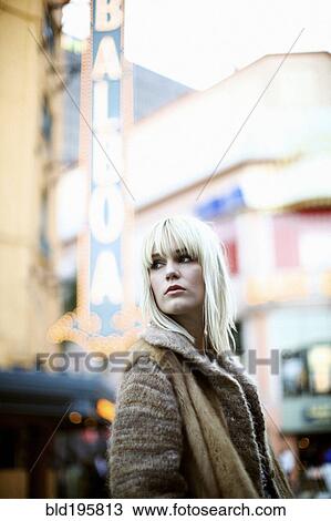 Stock Image - Caucasian woman standing outdoors in fur coat. Fotosearch