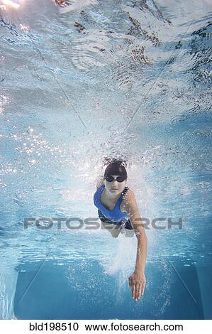 Stock Image - Caucasian woman swimming in swimming pool. Fotosearch