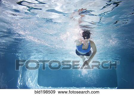 Stock Photo - Caucasian woman swimming in swimming pool. Fotosearch