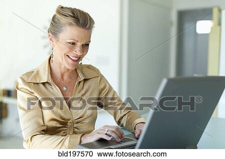 Stock Image - Caucasian woman typing on laptop. Fotosearch