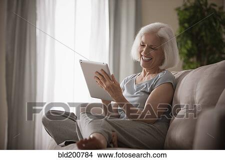 Picture - Caucasian woman using digital tablet. Fotosearch