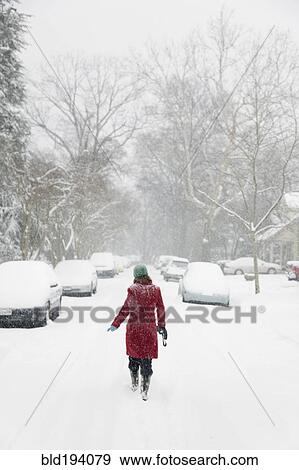 Stock Photo - Caucasian woman walking in snow storm. Fotosearch