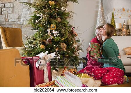 Picture - Caucasian women exchanging Christmas gifts. Fotosearch
