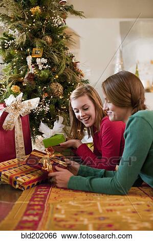 Caucasian women opening Christmas gifts View Large Photo Image Stock Photograph - Caucasian women opening Christmas gifts. Fotosearch