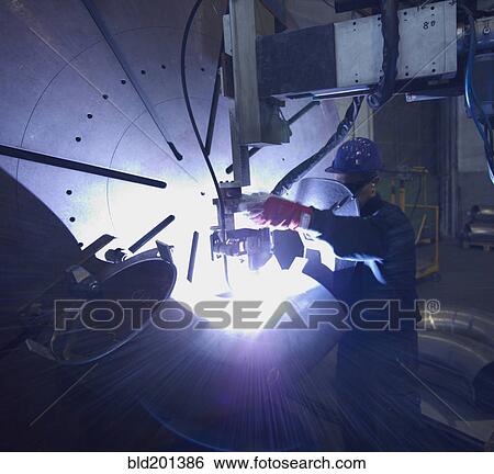 Stock Photograph - Caucasian worker working on steel pipe in factory. Fotosearch