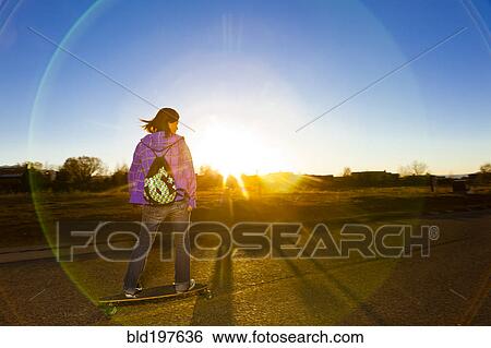 Chinese girl skateboarding on road at sunset View Large Photo Image Stock Photograph - Chinese girl skateboarding on road at sunset. Fotosearch