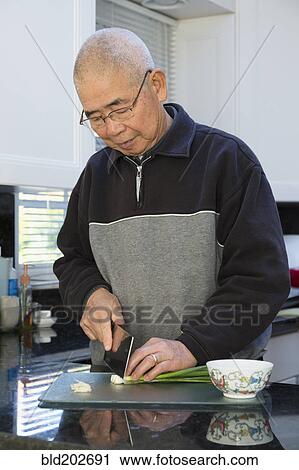 Chinese man chopping onions in kitchen View Large Photo Image Stock Image - Chinese man chopping onions in kitchen. Fotosearch