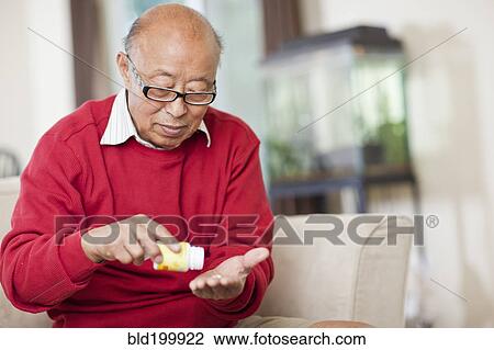 Stock Image - Chinese man taking medication. Fotosearch