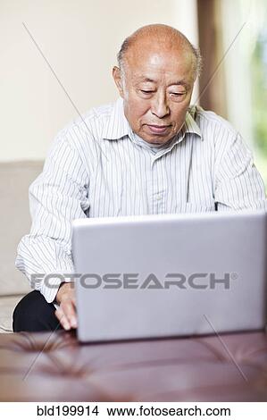 Chinese man using laptop View Large Photo Image Picture - Chinese man using laptop. Fotosearch