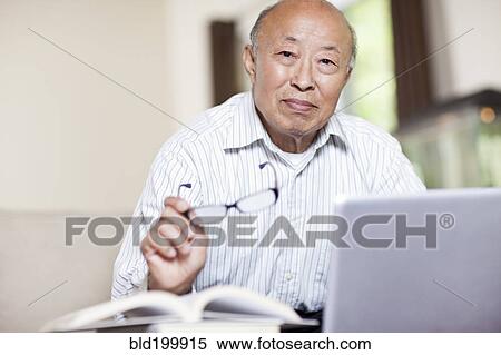 Chinese man with book and laptop View Large Photo Image Stock Photography - Chinese man with book and laptop. Fotosearch