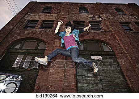 Picture - Chinese woman breakdancing in urban area. Fotosearch