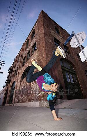 Stock Photography - Chinese woman breakdancing in urban area. Fotosearch