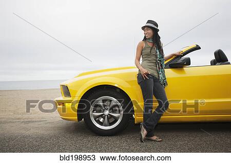 Chinese woman standing near convertible at beach View Large Photo Image Stock Image - Chinese woman standing near convertible at beach. Fotosearch