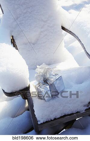 Christmas gift on chair in snow View Large Photo Image Stock Photograph - Christmas gift on chair in snow. Fotosearch