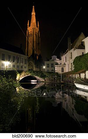 Stock Image - Church and buildings along canal at night. Fotosearch