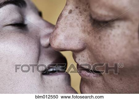 Stock Image - Close up of Caucasian lesbians kissing. Fotosearch