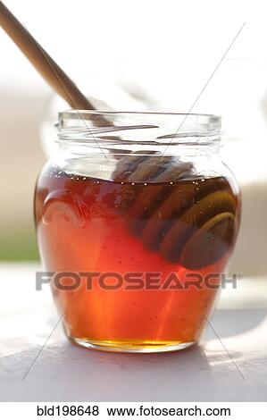 Stock Photo - Close up of honey and wooden dipper. Fotosearch