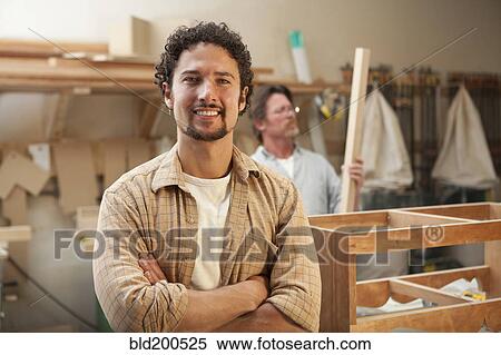 Stock Photography - Co-workers woodworking in workshop. Fotosearch