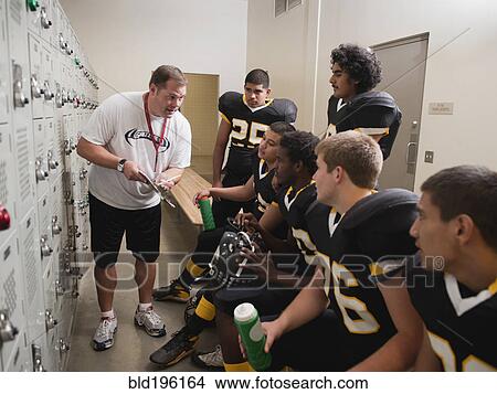 Coach talking to football players in locker room View Large Photo Image Picture - Coach talking to football players in locker room. Fotosearch