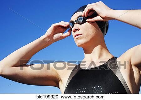 Stock Image - Competitive swimmer adjusting goggles. Fotosearch