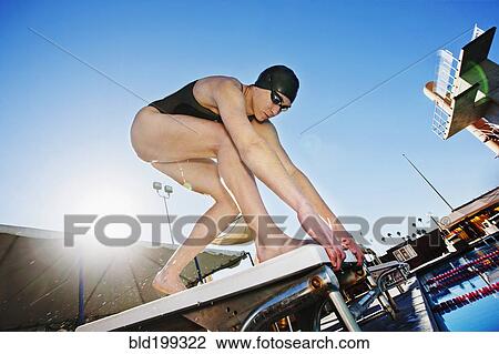 Competitive swimmer crouching on starting block View Large Photo Image Stock Image - Competitive swimmer crouching on starting block. Fotosearch