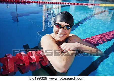 Stock Photo - Competitive swimmer leaning on rope in swimming pool. Fotosearch